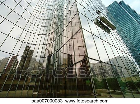 Stock Image - France, Paris, buildings reflected in glass facade of skyscraper. Fotosearch