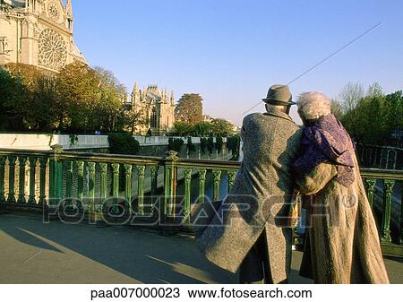 France, Paris, elderly couple walking arm in arm on bridge next to Notre Dame Cathedral View Large Photo Image Stock Image - France, Paris, elderly couple walking arm in arm on bridge next to Notre Dame Cathedral. Fotosearch
