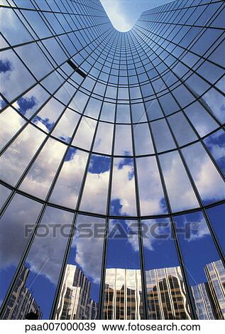 Stock Photo - France, Paris, glass facade of skyscraper, reflecting sky and buildings, low angle view. Fotosearch