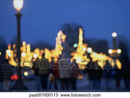 Stock Image - France, Paris, people and illuminations at night, blurred. Fotosearch