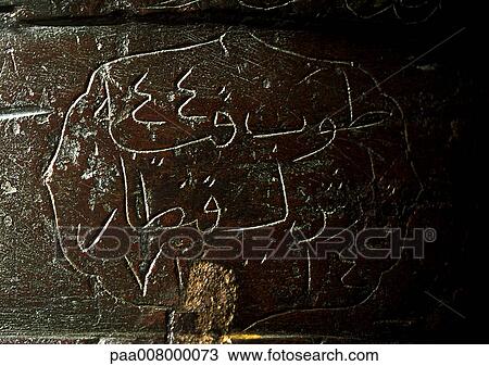 Stock Image - Arabic engraved in stone wall.. Fotosearch