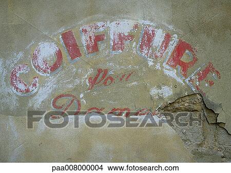 Hair salon type in French painted on worn down wall. View Large Photo Image Picture - Hair salon type in French painted on worn down wall.. Fotosearch