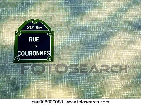 Rue des Couronnes street sign on tiled wall with shadows View Large Photo Image Stock Photo - Rue des Couronnes street sign on tiled wall with shadows. Fotosearch