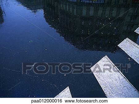 Building reflected on wet ground near cross-walk View Large Photo Image Stock Photograph - Building reflected on wet ground near cross-walk. Fotosearch