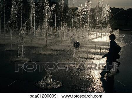 Stock Image - Children standing near fountain. Fotosearch