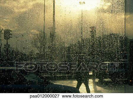 Drops of water on window, street scene in background View Large Photo Image Stock Photo - Drops of water on window, street scene in background. Fotosearch