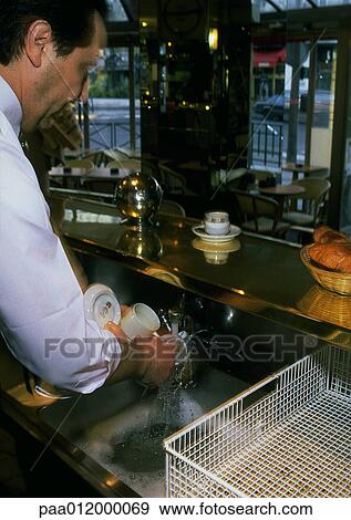 Man washing glasses in cafe View Large Photo Image Stock Photo - Man washing glasses in cafe. Fotosearch
