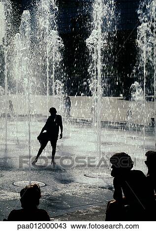 Person silhouetted, standing under fountains View Large Photo Image Stock Image - Person silhouetted, standing under fountains. Fotosearch