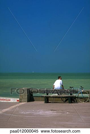 Person sitting on rail, overlooking sea View Large Photo Image Stock Photography - Person sitting on rail, overlooking sea. Fotosearch