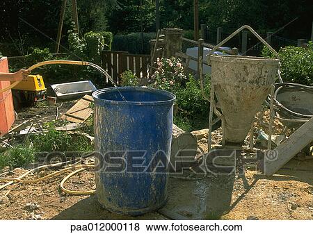 Stock Photo - Person using hose to put water into plastic barrel. Fotosearch