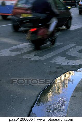 Picture - Puddle on road with traffic. Fotosearch