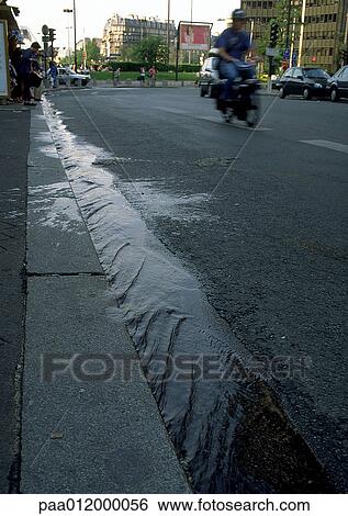Water flowing along street gutter View Large Photo Image Stock Photograph - Water flowing along street gutter . Fotosearch