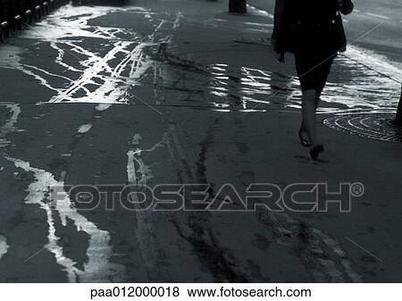 Woman walking on sidewalk with wet streaks, lower section View Large Photo Image Stock Photo - Woman walking on sidewalk with wet streaks, lower section. Fotosearch