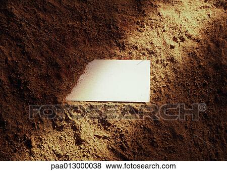 Stock Photo - Piece of paper partly covered with dirt, light shining across.. Fotosearch
