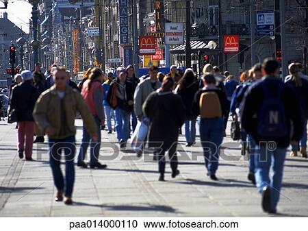 Stock Image - Crowd, dressed warmly, walking on sidewalk in city, blurred.. Fotosearch
