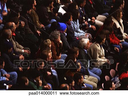 Stock Image - Crowd of people sitting, blurred.. Fotosearch