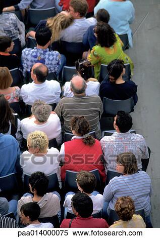 Stock Photography - Crowd sitting in chairs, high angle rear view. Fotosearch