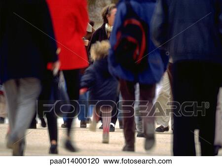Stock Image - Crowd walking, lower section, blurred motion. Fotosearch