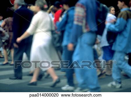 Stock Image - Crowd walking on sidewalk, blurred.. Fotosearch