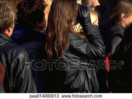 Stock Image - Group of people in black jackets, in crowd, blurred.. Fotosearch