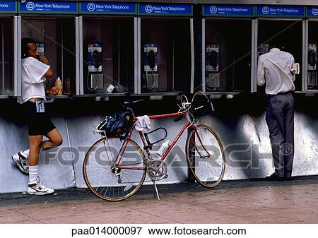NY, NY, two men using pay phones, one with bike View Large Photo Image Stock Photo - NY, NY, two men using pay phones, one with bike. Fotosearch