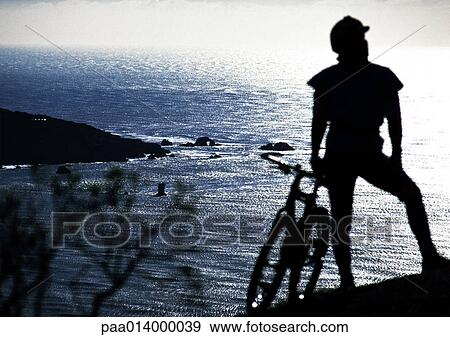 Person with bike overlooking the water, silhouette. View Large Photo Image Stock Photo - Person with bike overlooking the water, silhouette.. Fotosearch