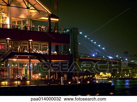 Stock Image - Restaurant on the water at night, blurred. Fotosearch