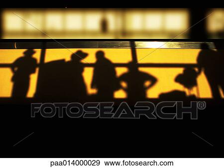 Stock Photo - Shadows of people standing behind railing, low angle view. Fotosearch