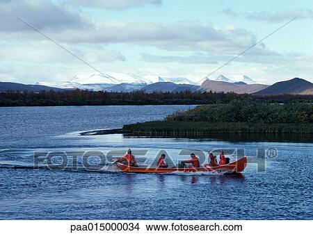 Picture - Finland, people in canoe on lake. Fotosearch
