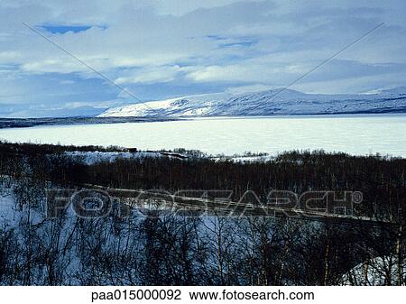Stock Image - Finland, snow covered landscape with mountains. Fotosearch