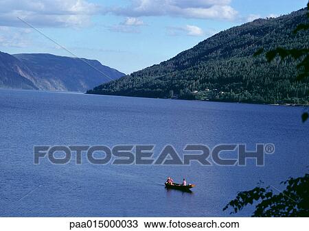 Stock Image - Norway, people in rowboat near fjords. Fotosearch