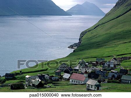 Stock Image - Scandinavia, village overlooking sea with mountains in background. Fotosearch