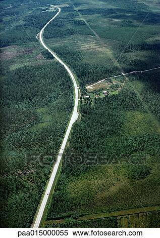 Stock Photography - Sweden, road through forest landscape, aerial view. Fotosearch