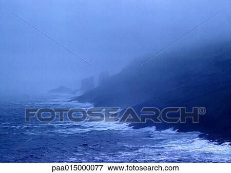 Stock Photo - Waves hitting coast in fog. Fotosearch