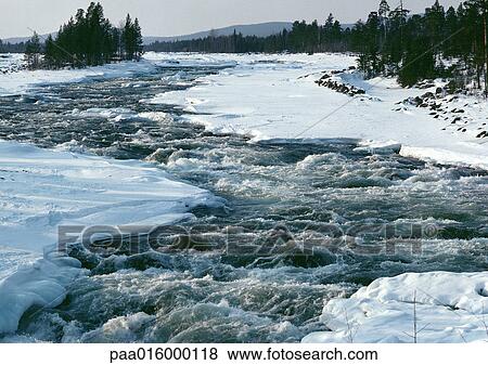 Stock Photo - Sweden, river running through snowy banks. Fotosearch
