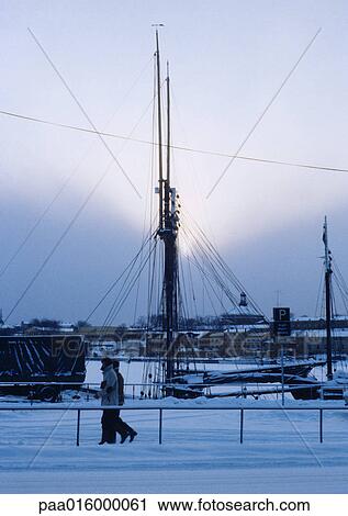 Sweden, Stockholm, two people walking along quay, boat mast in background View Large Photo Image Stock Image - Sweden, Stockholm, two people walking along quay, boat mast in background. Fotosearch