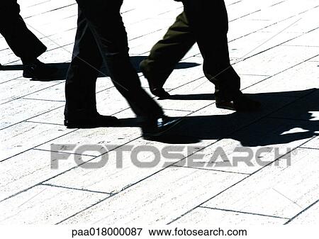 Stock Photo - Businessmen walking, lower section. Fotosearch
