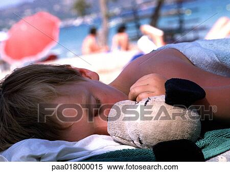 Child sleeping with doll at beach. View Large Photo Image Stock Photography - Child sleeping with doll at beach.. Fotosearch