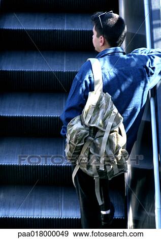 Man riding escalator, rear view. View Large Photo Image Stock Photo - Man riding escalator, rear view.. Fotosearch