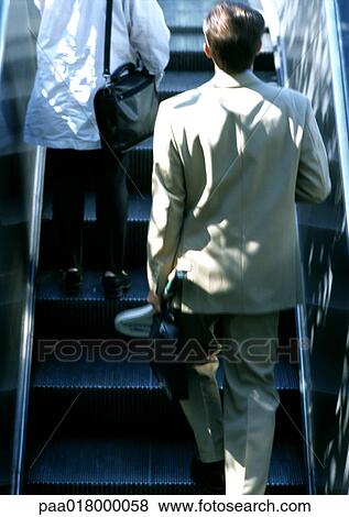 People riding escalator, rear view. View Large Photo Image Stock Photo - People riding escalator, rear view.. Fotosearch