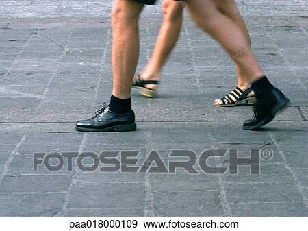 Stock Photo - People walking, view from knees down, blurred.. Fotosearch
