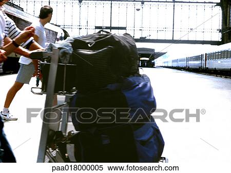 Person pushing luggage on cart at train station. View Large Photo Image Stock Photography - Person pushing luggage on cart at train station.. Fotosearch