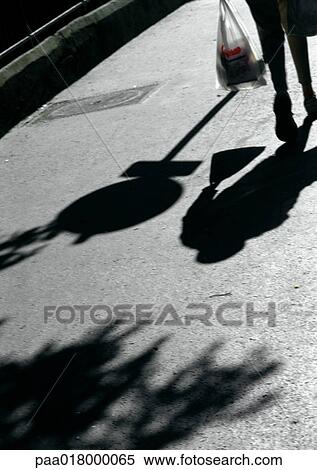 Person walking on street with bag, shadows. View Large Photo Image Stock Photography - Person walking on street with bag, shadows.. Fotosearch