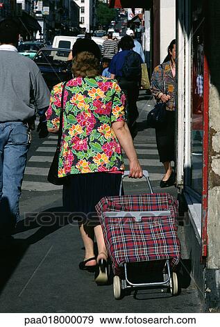 Woman pulling caddy, rear view. View Large Photo Image Stock Photo - Woman pulling caddy, rear view.. Fotosearch