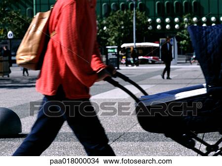 Woman pushing a stroller, in financial district, mid section View Large Photo Image Picture - Woman pushing a stroller, in financial district, mid section. Fotosearch
