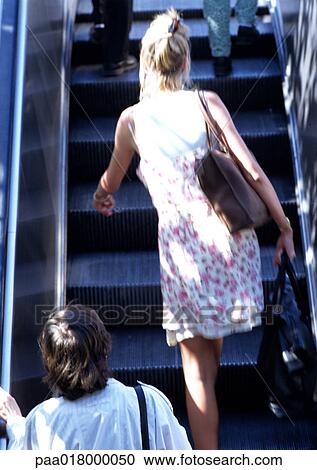 Woman walking up escalator, rear view. View Large Photo Image Stock Image - Woman walking up escalator, rear view.. Fotosearch