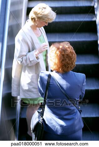 Women riding escalator View Large Photo Image Stock Image - Women riding escalator. Fotosearch