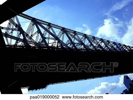 Stock Image - Bridge seen from angle, silhouetted against sky.. Fotosearch