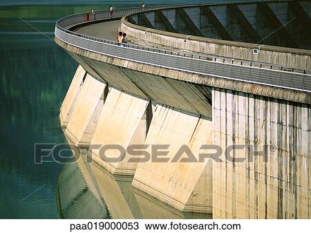 Stock Image - France, Savoie, Roseland Dam, people looking over edge at water. Fotosearch
