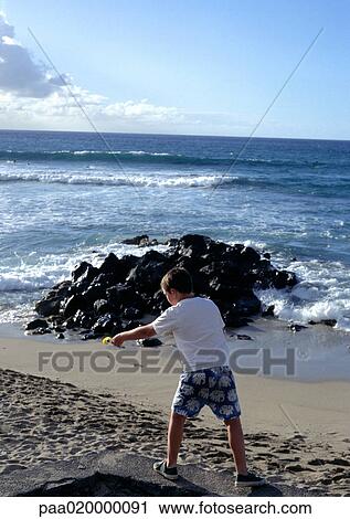 Stock Image - Child playing on beach. Fotosearch